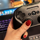 A photo of a gaming controller in front of a computer with a cloud gaming suite on it